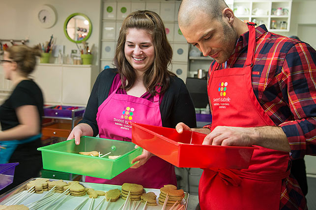 Un couple a du plaisir à décorer des biscuits chez Sweet Isabelle